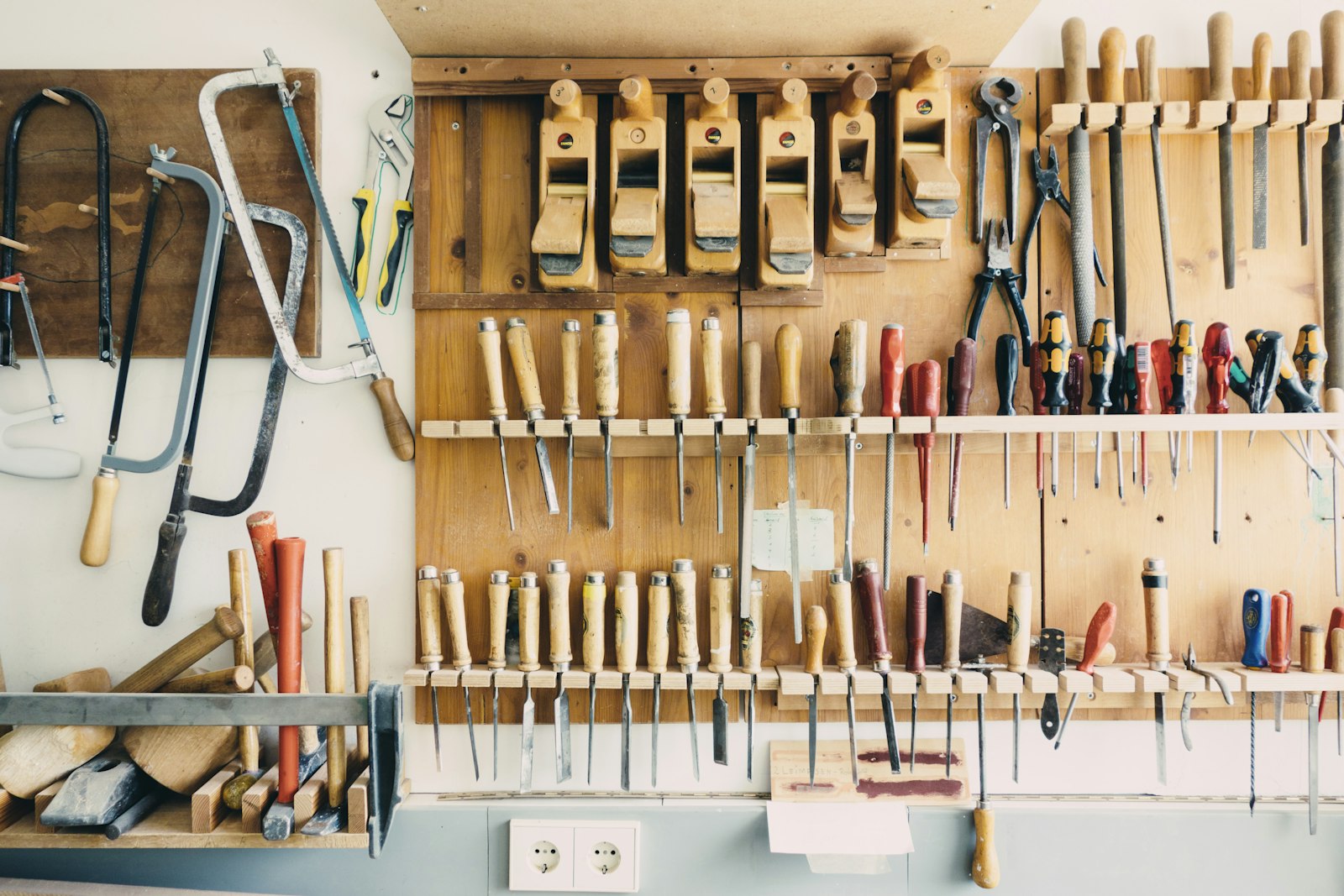 Mur d'outils à main de l'atelier : ciseaux à bois, rabots et gouges rangés
